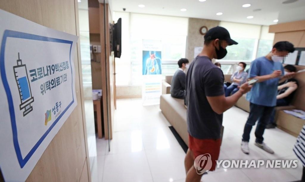 Des citoyens portant des masques attendent de recevoir leur vaccin contre le nouveau coronavirus (Covid-19) dans un établissement médical à Séoul, le 10 juin 2021.