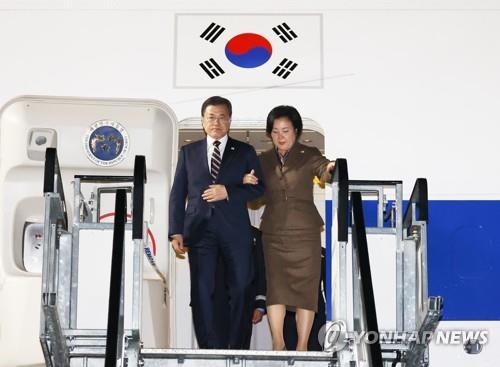 Le président Moon Jae-in et son épouse Kim Jung-sook descendent de l'avion après leur arrivée à l'aéroport international de Glasgow en Ecosse, le dimanche 31 octobre 2021(heure locale), afin d'assister à la 26e Conférence des parties de la Convention-cadre des Nations unies sur les changements climatiques (COP26). 