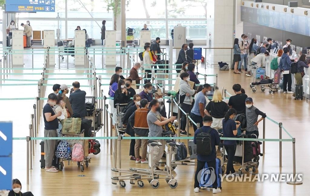 Des voyageurs font la queue avant de s'enregistrer pour l'embarquement au terminal 1 de l'aéroport international d'Incheon, à l'ouest de Séoul, le vendredi 13 mai 2022.