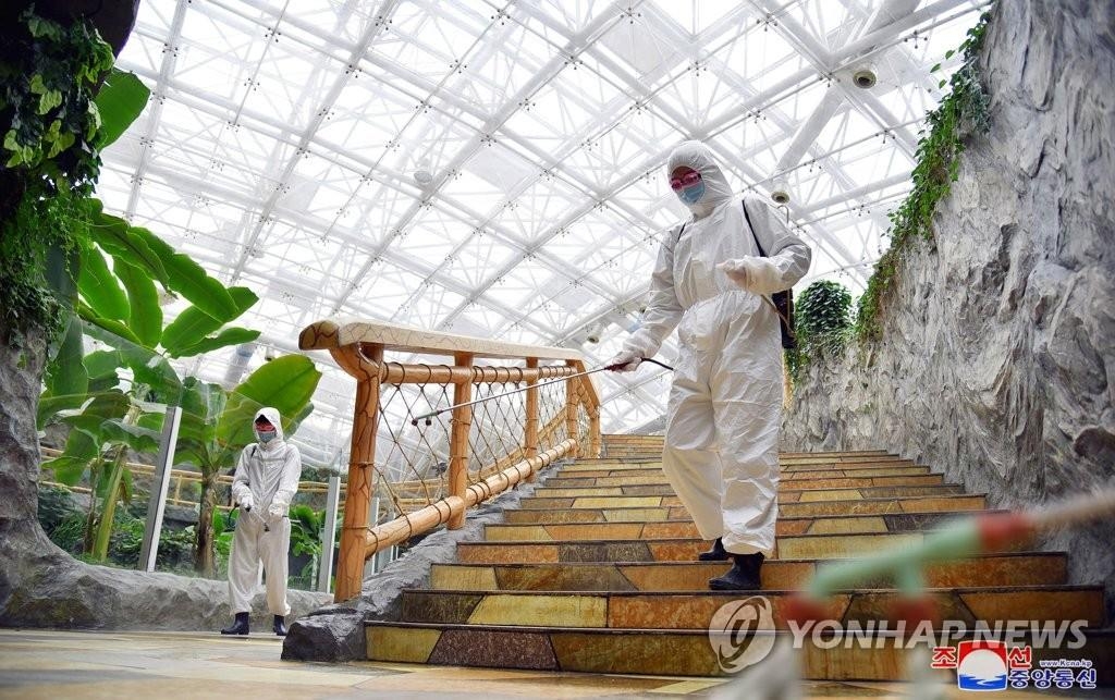 Cette photo d'archives publiée par l'Agence centrale de presse nord-coréenne (KCNA) le 20 mai 2022, montre des responsables de la santé effectuant des travaux de désinfection au zoo central de Pyongyang. (Utilisation en Corée du Sud uniquement et reproduction interdite)