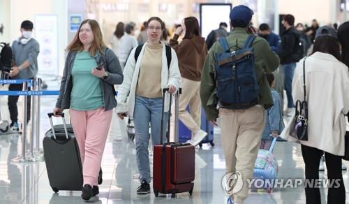 Des voyageurs sans masque sont à l'aéroport international d'Incheon, à l'ouest de Séoul, le lundi 20 mars 2023, premier jour de la levée de l'obligation de port du masque dans les transports en commun. 