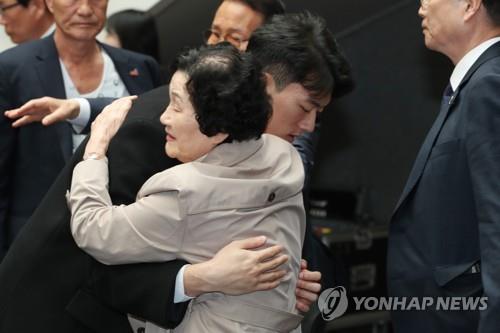 Chun Woo-won (à g.), petit-fils de l'ancien président Chun Doo-hwan, embrasse une membre de famille d'une victime de la répression contre un soulèvement démocratique en 1980 à Gwangju, le vendredi 31 mars 2023. 