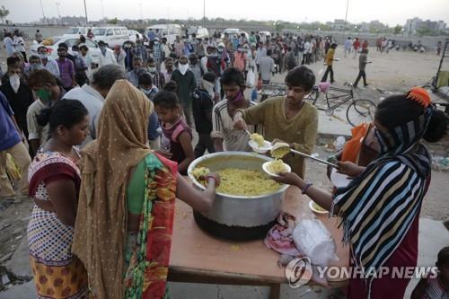 인도 아메다바드의 무료 급식소에 줄을 선 저소득층. [AP=연합뉴스]