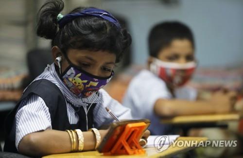 인도 뭄바이의 '디지털 모바일 교육 도서관'에서 마스크를 쓰고 온라인으로 수업을 듣는 어린이. [로이터=연합뉴스] 