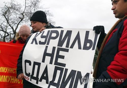 '쿠릴 절대 포기 못 한다'는 내용의 팻말을 든 러시아 공산당원.