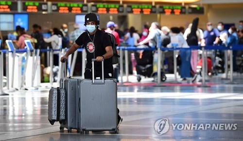 지난달 27일 미 LA국제공항에서 한 남성이 여행 가방 여러 개를 끌며 가고 있다. [AFP=연합뉴스 자료사진]