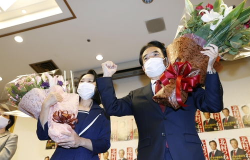 (야마구치 교도=연합) = 24일 치러진 일본 참의원 야마구치 선거구 보선에서 당선한 자민당 기타무라 쓰네오(北村経夫·66) 후보가 꽃다발을 들고 기뻐하고 있다. 