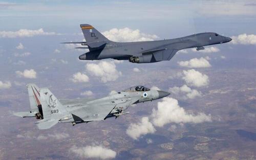 이스라엘군의 F-15 전투기(아래) 호위를 받으며 비행하는 미군 B-1B 전략폭격기(위)