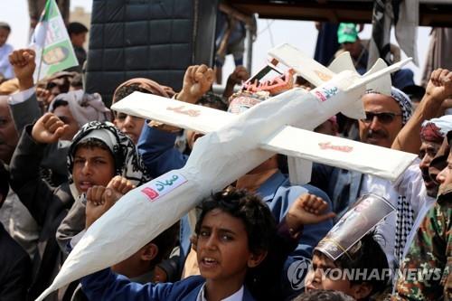 후티 반군 지지자들이 모조 드론을 집회에서 나르고 있는 모습
