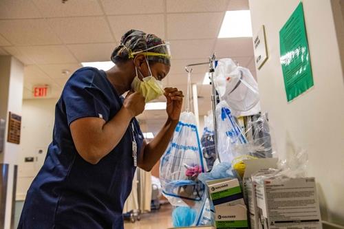 미국 유매스 메모리얼 의료센터에서 중환자실에 들어가기 전 마스크 쓰는 간호사