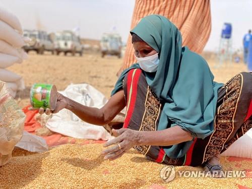 지난 2월 소말리아 난민 캠프에서 곡식을 모으는 한 여성