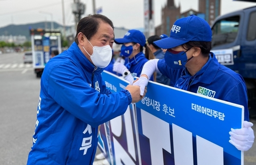 선거운동원과 악수하는 김재무 후보