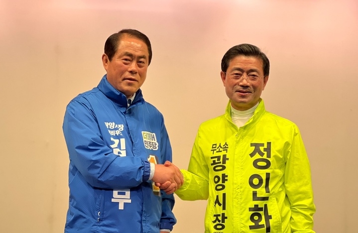 악수하는 김재무(왼쪽)·정인화 후보