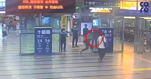 A씨가 강아지가 담긴 가방으로 안내판을 가격하는 모습
