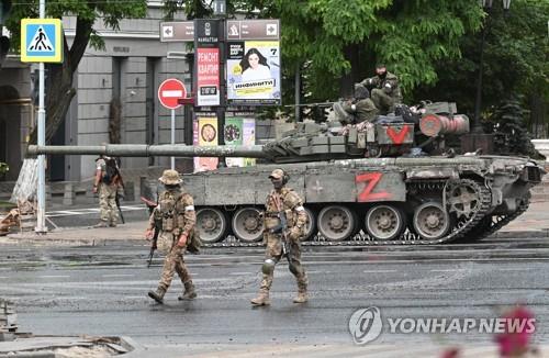 러 사령부 겨눈 용병그룹 장갑차 대포…주민들은 사진 찍기도