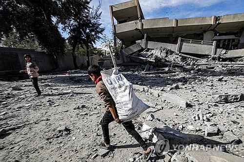가자지구에서 UNRWA 적힌 봉지 들고가는 소년