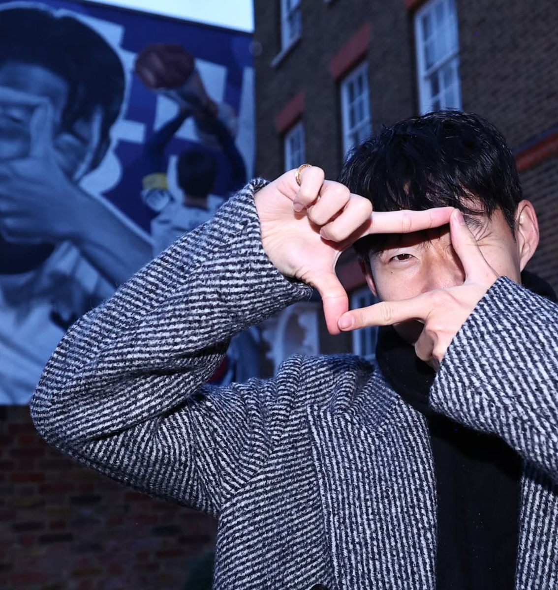 자신의 모습이 단긴 벽화 앞에서 찰칵 세리머니를 펼치는 손흥민