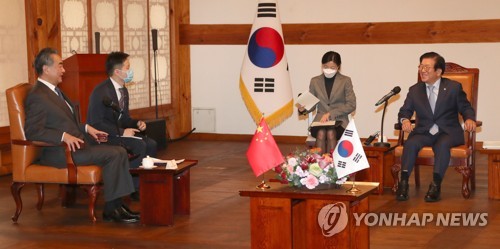 El presidente de la Asamblea Nacional, Park Byeong-seug (dcha.) habla con el ministro de Asuntos Exteriores chino, Wang Yi (izda.), durante una reunión, celebrada, el 27 de noviembre de 2020, en Seúl.