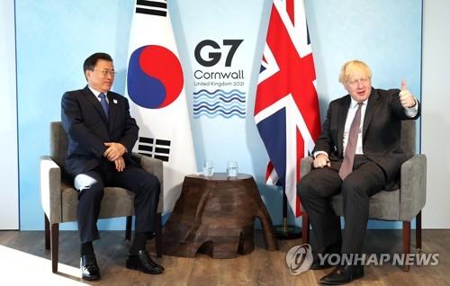 El presidente surcoreano, Moon Jae-in (izda.), y el primer ministro británico, Boris Johnson, sostienen una reunión cumbre bilateral, el 13 de junio de 2021, en el condado británico de Cornualles, al margen de la cumbre del G-7.