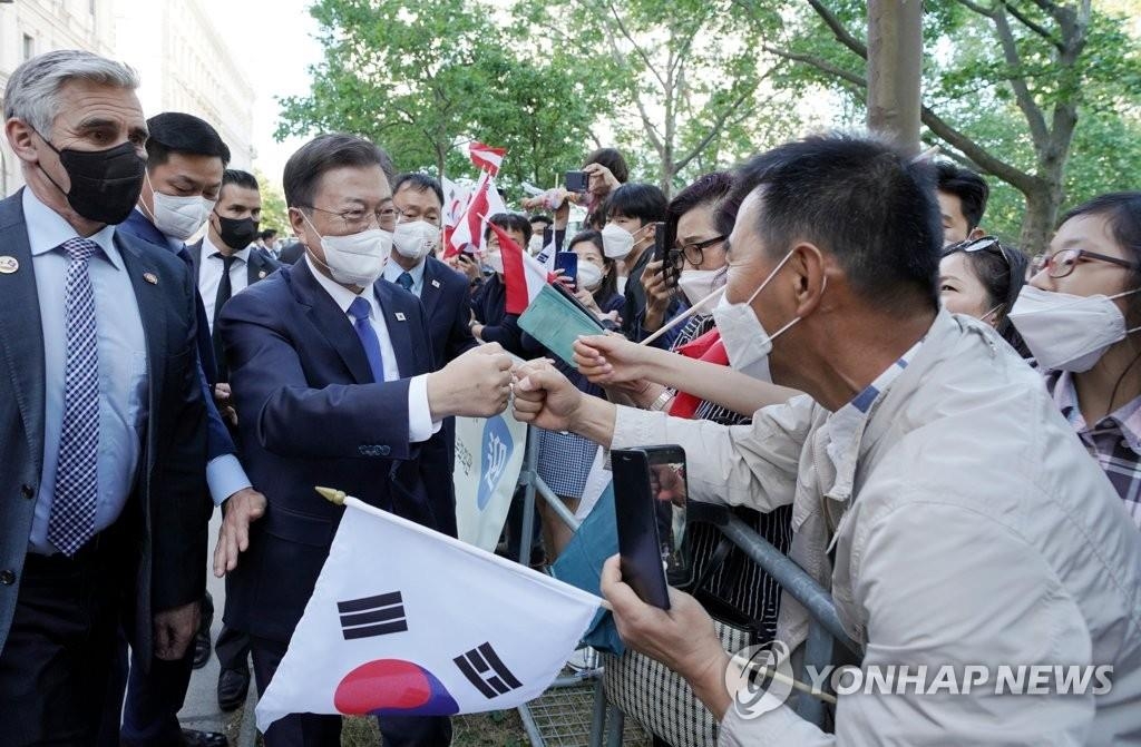 El presidente surcoreano, Moon Jae-in (segundo por la izda.), es recibido por un grupo de residentes surcoreanos en Viena, Austria, el 13 de junio de 2021 (hora local), después de llegar al país europeo para efectuar una visita de Estado de tres días.