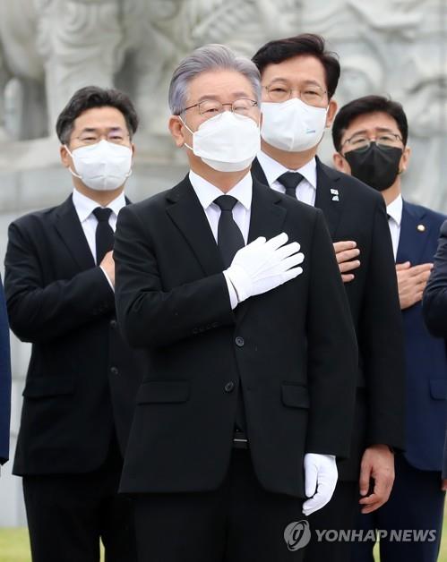 El gobernador de Gyeonggi, Lee Jae-myung (centro), saluda a la bandera nacional, el 11 de octubre de 2021, en el cementerio nacional en la ciudad central de Daejeon, después de ganar, el día anterior, las primarias del gobernante Partido Democrático para las elecciones presidenciales de 2022.