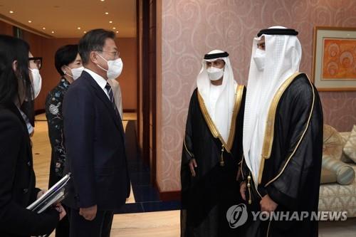 El presidente surcoreano, Moon Jae-in (izda.), dialoga con el ministro de Energía e Infraestructura de los los Emiratos Árabes Unidos (EAU), Suhail Mohamed Al Mazrouei (segundo por la dcha.), y Abdulla Saif Al Nuaimi, embajador de los EAU ante Corea del Sur, el 15 de enero de 2022 (hora local), tras llegar al aeropuerto real en Dubái, en la primera visita de su gira por Oriente Medio.