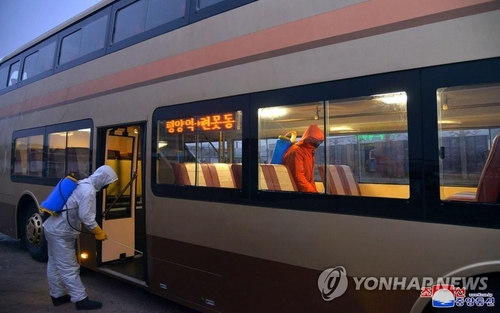 La foto sin fechar, publicada, el 19 de febrero de 2021, por la KCNA, muestra a funcionarios desinfectando un bus en Pyongyang, en medio de la pandemia del coronavirus. (Uso exclusivo dentro de Corea del Sur. Prohibida su distribución parcial o total)