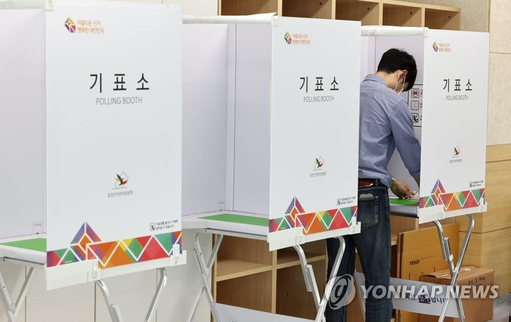 Un funcionario electoral revisa una cabina de votación, el 25 de mayo de 2022, en un centro de votación en Seúl, un día antes del inicio de un período de votación anticipada de dos días para las elecciones locales del 1 de junio.