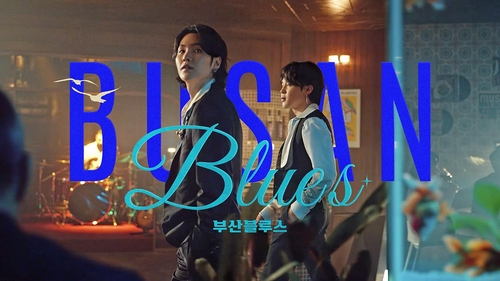 La imagen, proporcionada por la Organización de Turismo de Corea del Sur, muestra a Suga (izda.) y Jimin, miembros del grupo masculino de K-pop BTS, en una escena del vídeo de la versión de Busan de la campaña "Feel the Rhythm of Korea 2022". (Prohibida su reventa y archivo)