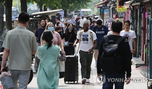 La foto de archivo, tomada el 29 de mayo de 2022, muestra a turistas extranjeros en una calle en el barrio de Itaewon, en Seúl.