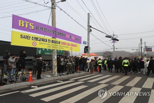 Los reporteros de medios de comunicación locales y extranjeros esperan la llegada de Jin, de BTS, el 13 de diciembre de 2022, fuera de un campo de entrenamiento en Yeoncheon, a 60 kilómetros al norte de Seúl.