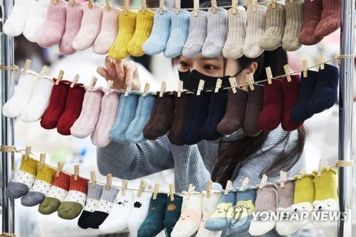 Una empleada exhibe varios patucos en una exposición celebrada, el 5 de febrero de 2023, en Suwon, al sur de Seúl.