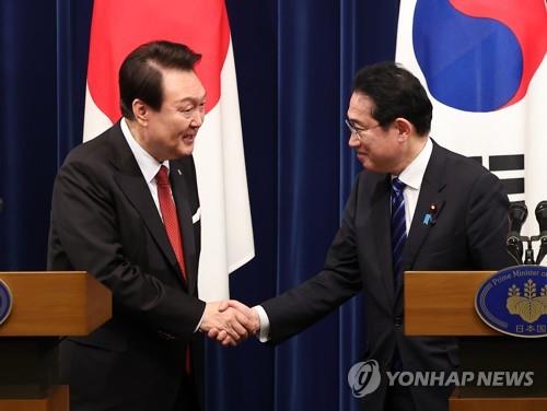 La foto muestra al presidente surcoreano, Yoon Suk Yeol (izda.), estrechando la mano del primer ministro japonés, Fumio Kishida, al concluir una conferencia de prensa conjunta tras su cumbre, celebrada, el 16 de marzo de 2023, en Tokio.
