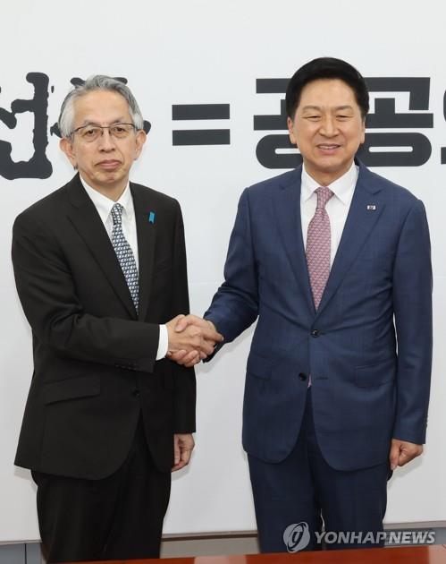El legislador Kim Gi-hyeon (dcha.), líder del gobernante Partido del Poder del Pueblo, estrecha la mano del embajador de Japón en Corea del Sur, Koichi Aiboshi, el 8 de junio de 2023, en la Asamblea Nacional, en Seúl.