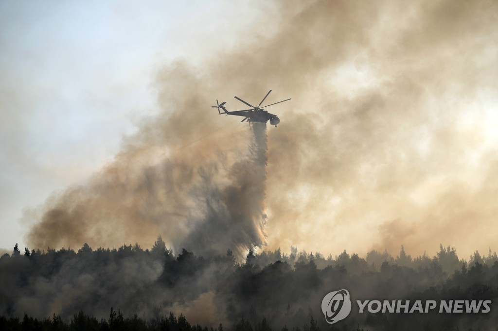 4일(현지시간) 그리스에서 헬리콥터가 화재 지역에 물을 뿌리고 있다. [AP=연합뉴스]