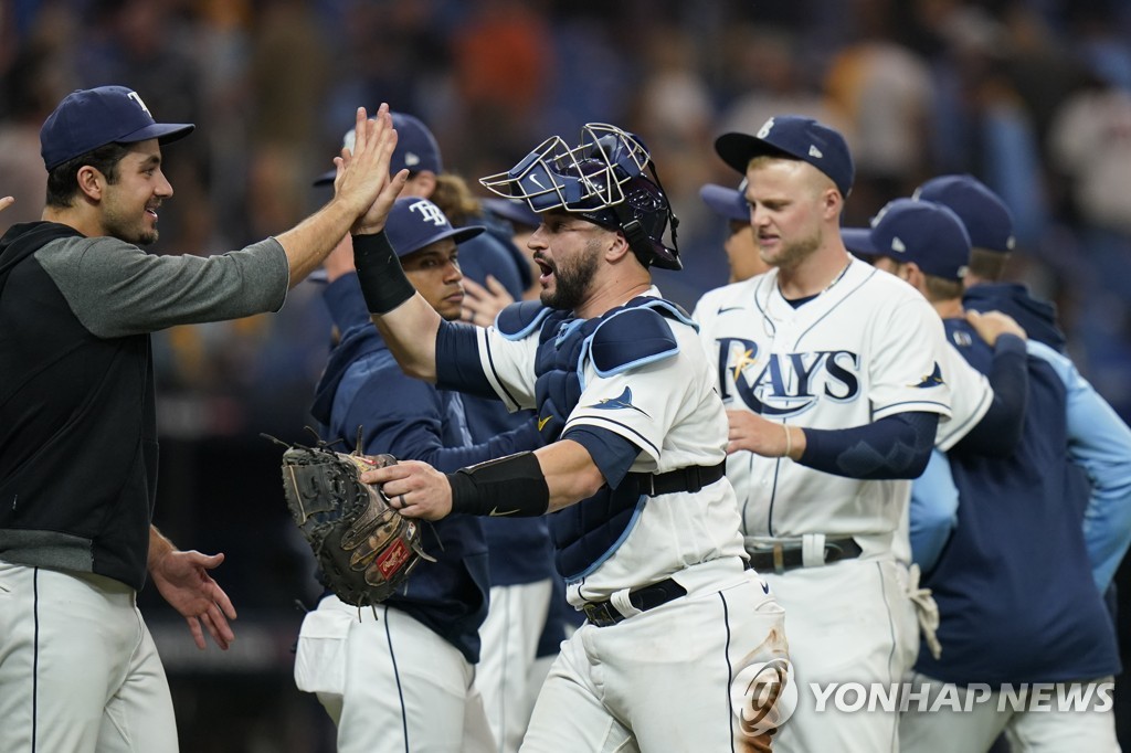 In this Associated Press photo, members of the Tampa Bay Rays celebrate their 5-0 victory over the Boston Red Sox in Game 1 of the American League Division Series at Tropicana Field in St. Petersburg, Florida, on Oct. 7, 2021. (Yonhap)