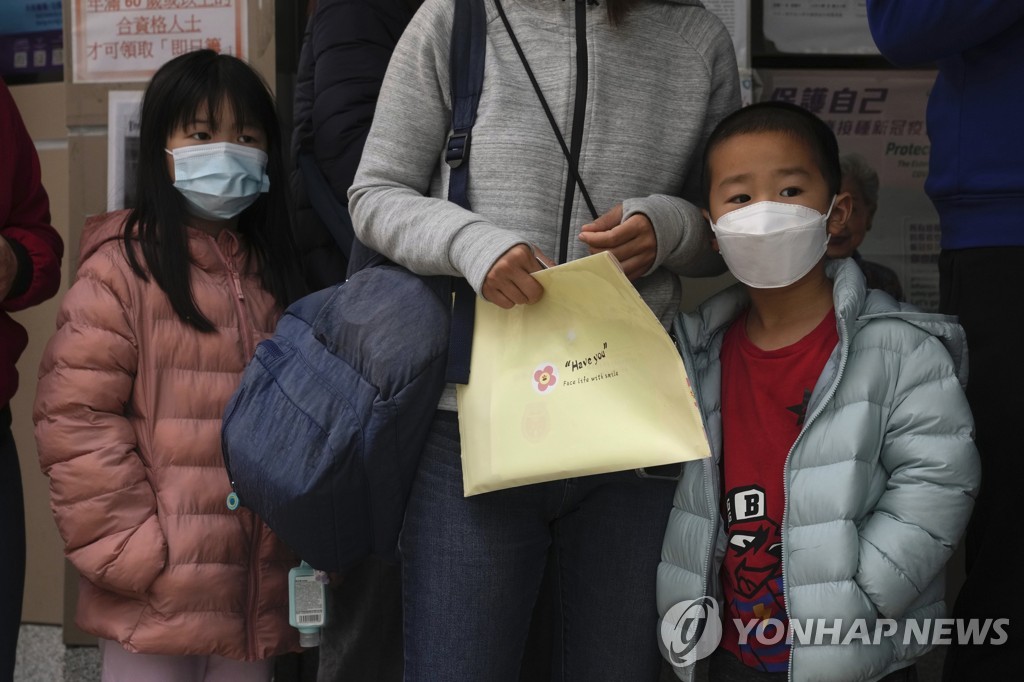 (AP=연합뉴스) 홍콩에서 지난 15일 시노백 백신의 접종 연령이 3세로 낮아지자 한 부모가 자녀들을 데리고 접종 센터를 찾은 모습. 2022.2.16.
