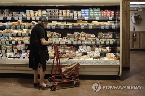 슈퍼마켓에서 가격표를 보고 있는 미국 소비자