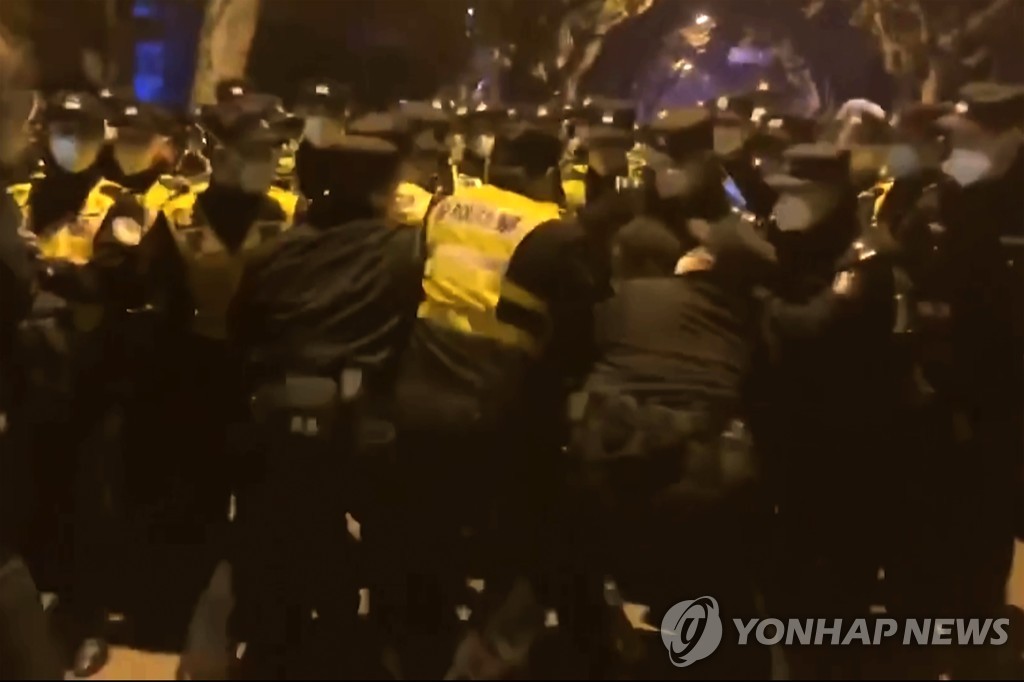 (AP=연합뉴스) 지난달 27일 중국 상하이에서 발생한 제로 코로나 반대 시위 현장에서 경찰이 사람들을 단속하는 모습. 2022.12.4.