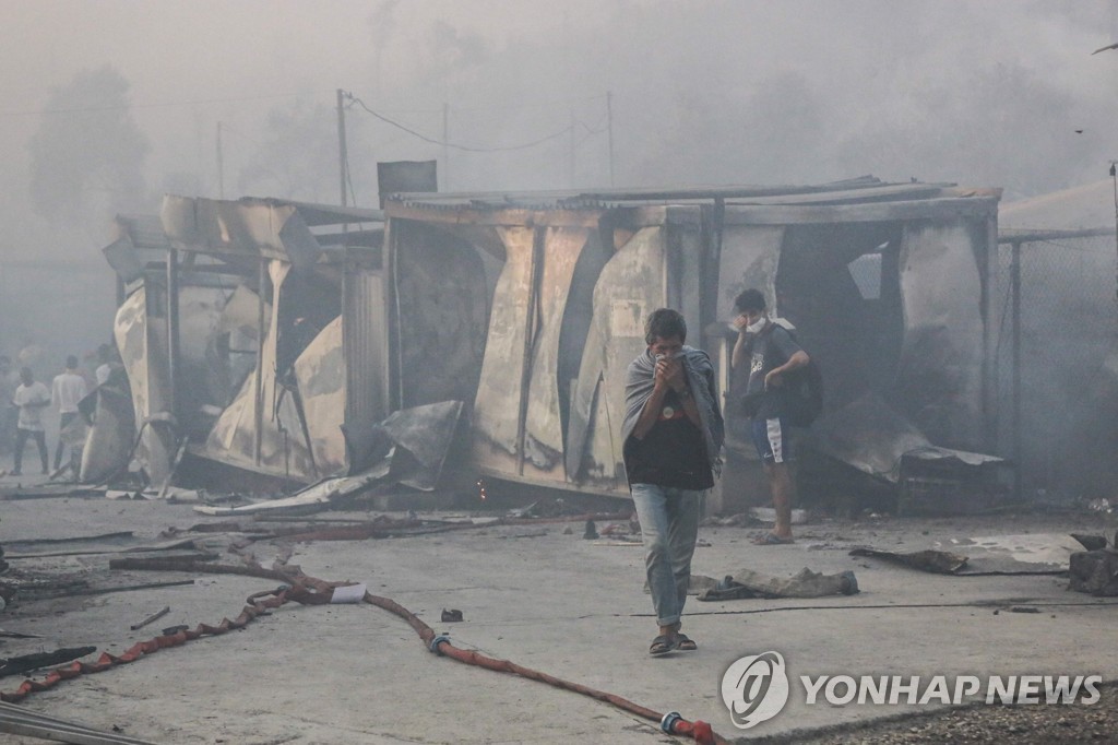 불에 탄 '모리아'에서 걸어 나오는 난민들의 모습