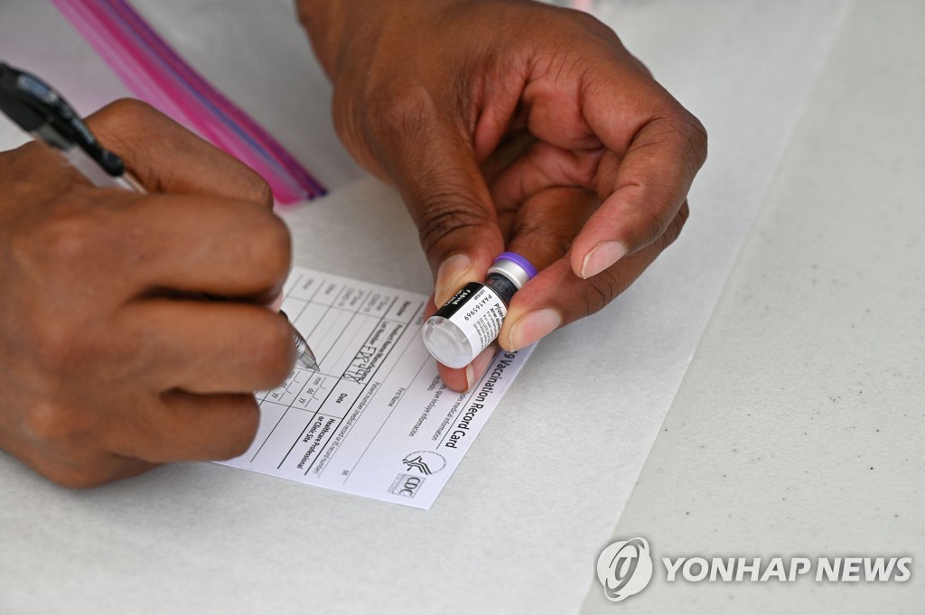 백신 증명서를 기입하고 있는 의료진.