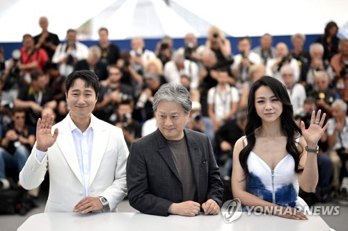 In this AFP photo, South Korean director Park Chan-wook (C), and cast members of his new film "Decision to Leave" -- Park Hae-il (L) and Tang Wei (R) -- pose for photographers during the 75th Cannes Film Festival in Cannes, France, on May 24, 2022. (Yonhap)