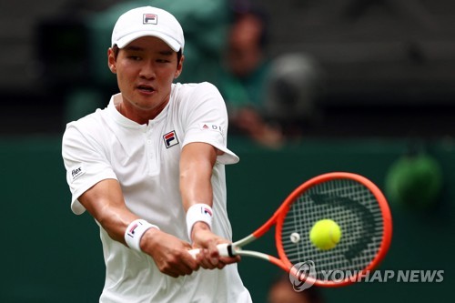 In this AFP file photo from June 27, 2022, Kwon Soon-woo of South Korea hits a shot against Novak Djokovic of Serbia during their men's singles first round match at Wimbledon at All England Club in London. (Yonhap)