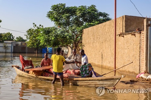 지난 18일 차드 수도 은자메나에서 홍수 속에 사람들이 가재도구를 건지는 모습 