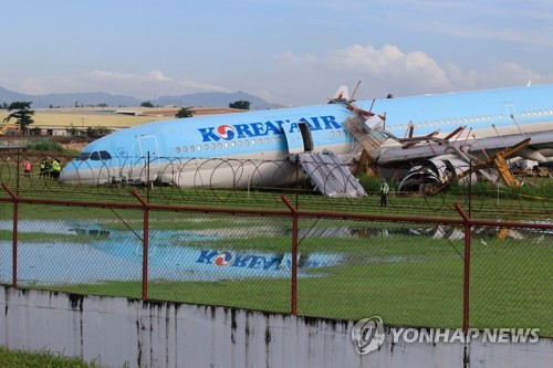 This AFP photo shows a Korean Air plane lying with its belly on the runway at the airport in Cebu City, central Philippines, on Oct. 24, 2022, after it overshot the runway the night before while landing in bad weather. (Yonhap) 
