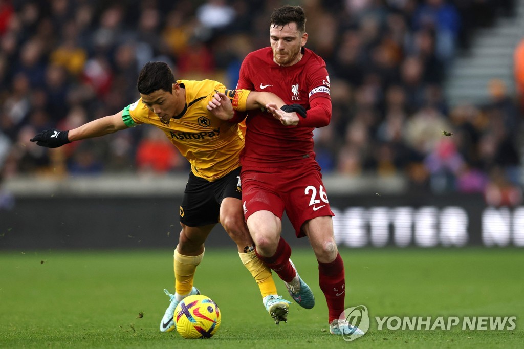 In this AFP photo, Hwang Hee-chan of Wolverhampton Wanderers (L) and Andrew Robertson of Liverpool battle for the ball during the clubs' Premier League match at Molineux Stadium in Wolverhampton, England, on Feb. 4, 2023. (Yonhap)