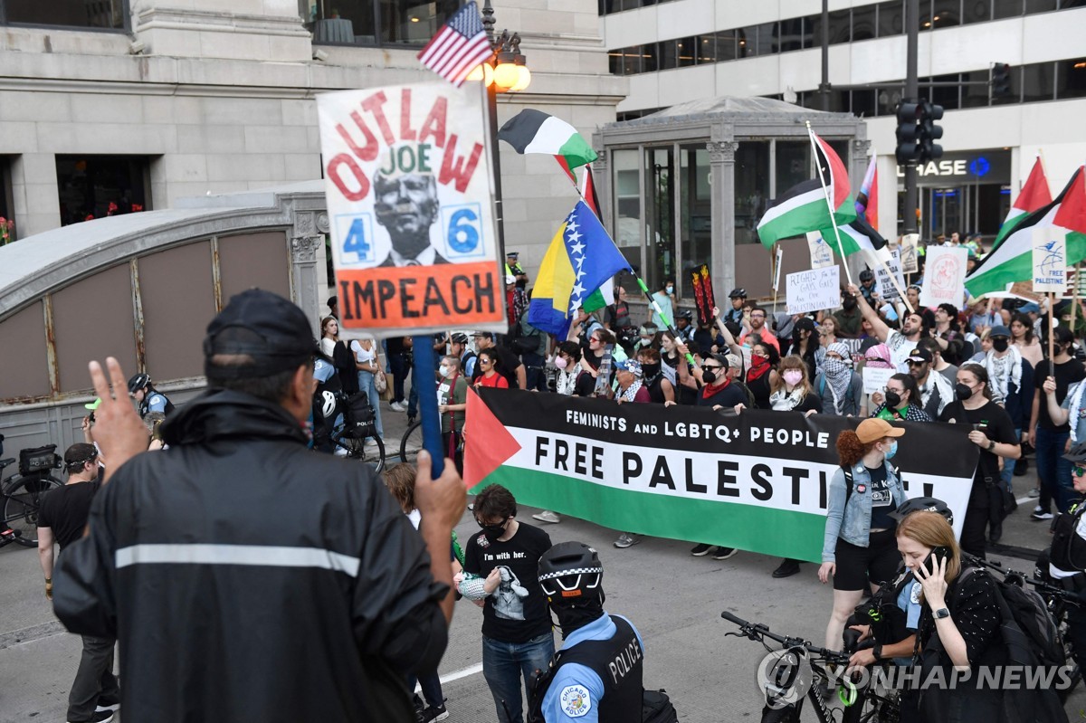 Esta fotografía, difundida por AFP, muestra a manifestantes ondeando banderas palestinas durante una protesta para exigir justicia reproductiva, defender los derechos de las personas trans y queer y exigir un alto el fuego en Gaza en vísperas de la Convención Nacional Demócrata en el United Center de Chicago, Illinois, el 18 de agosto de 2024. (Yonhap)