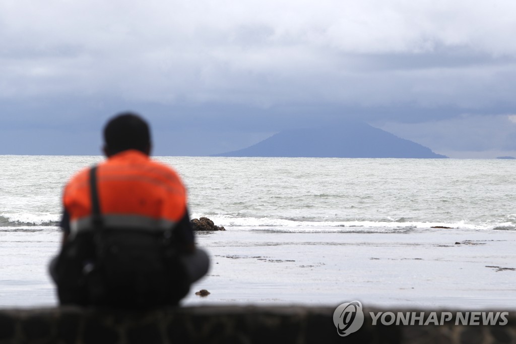 2018년 12월 26일 순다해협에 면해 있는 인도네시아 반텐 주 짜리따 해변에서 한 구조대원이 앞바다에 있는 아낙 크라카타우 화산을 바라보고 있다. [EPA=연합뉴스]