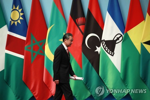 아프리카 국기 앞을 지나가는 왕이 중국 외교부장