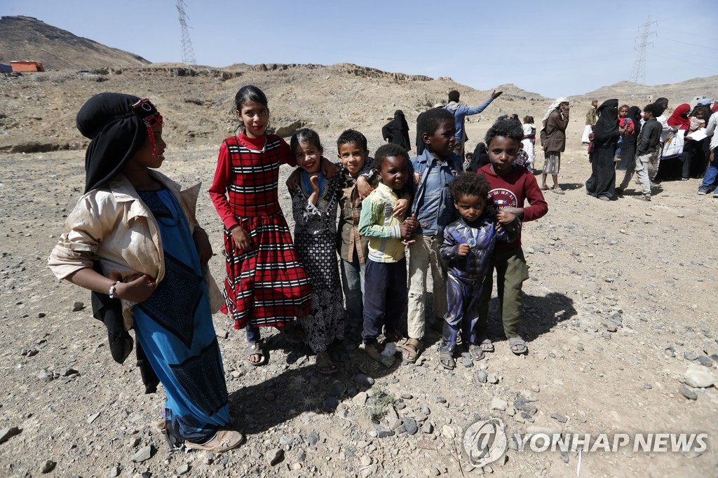 지난 1일(현지시간) 예멘 수도 사나의 한 피난처에 아이들이 음식을 구하기 위해 모여있다.